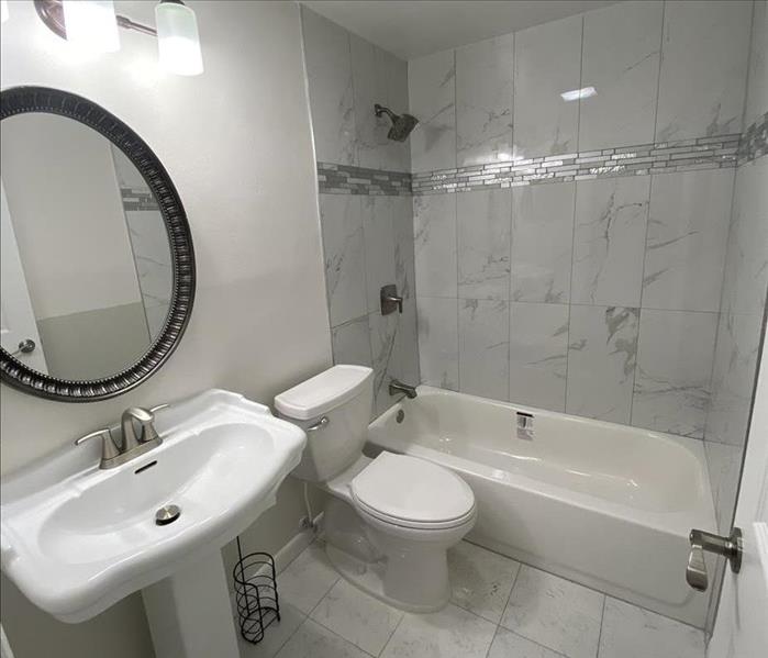 white bathroom with tub, sink and toilet