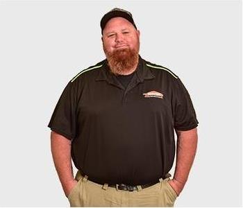 Technician in black polo in front of white background