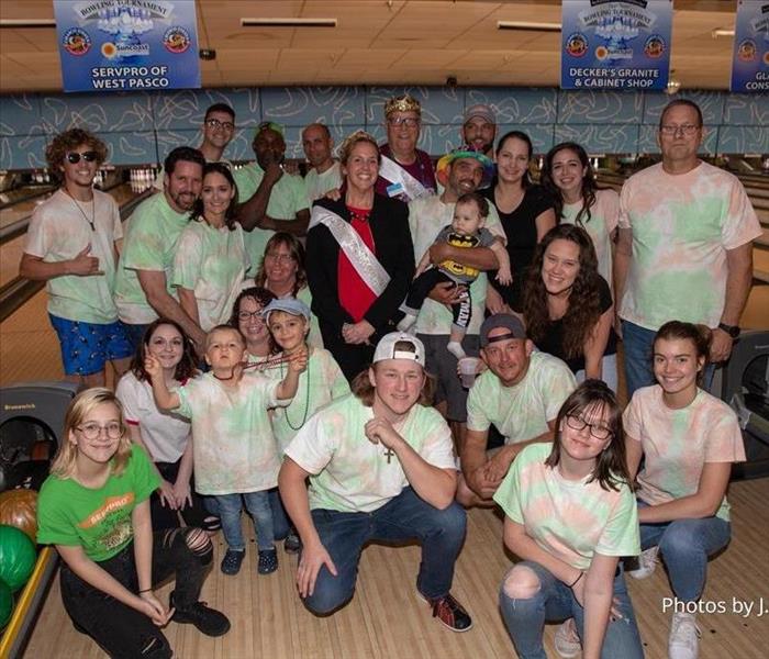 Group of people in front of bowling lanes in tie dye shirts